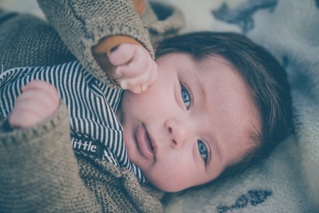 Sell back baby clothes-Baby wearing blue and brown winter outfit.