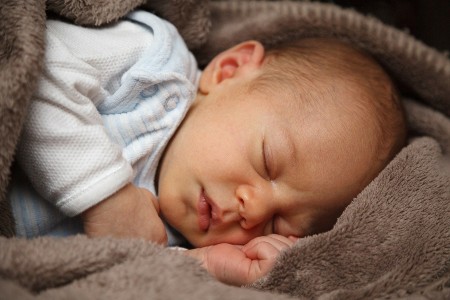 Sell back baby clothes-Baby sleeping comfortable on soft blankets.