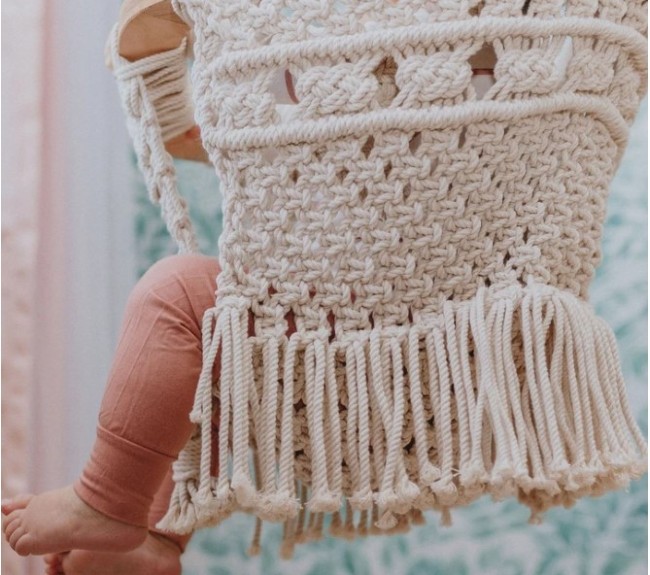 What is an infant swing?-Baby sitting in organic macramé swing displaying pretty details of the swing. 