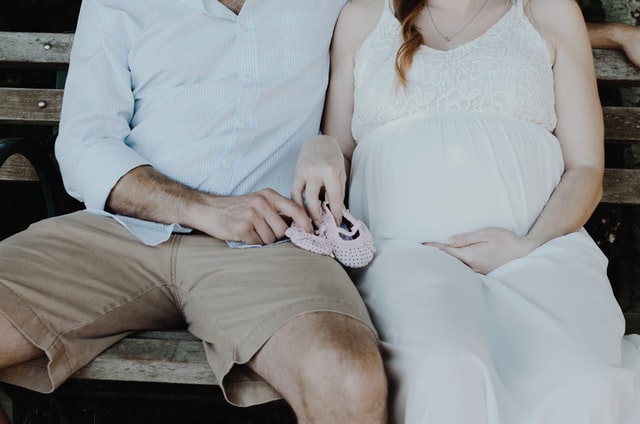 What's a baby registry?-Expecting couple holding a pair of little baby shoes.