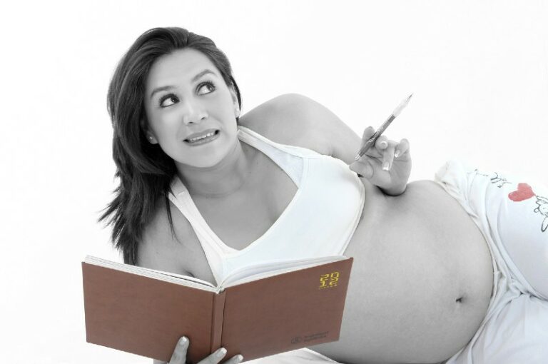 What's a baby registry?-Pregnant women writing notes in her schedule.