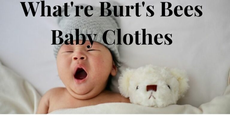 What're Burt's Bees baby clothes?-Yawning baby with hat in bed with soft toy.