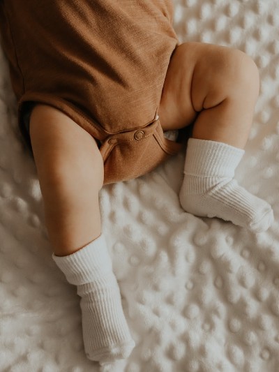 What're Gerber baby clothes?-Baby wearing brown bodysuit and white socks.