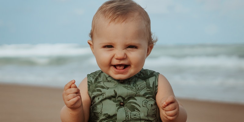Are Bamboo baby clothes Eo-friendly?Baby on the beach smiling.