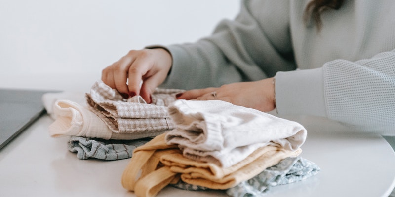 Is a baby clothes subscription worth it? Women Faulding baby clothes.